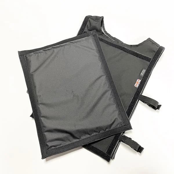 A black CED training vest and rectangular leg guard for manikins overlap on a white background.
